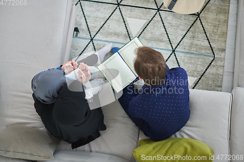 Image of Top view of young muslim family reading Quran during Ramadan