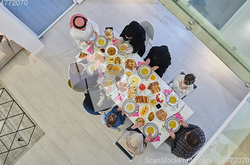 Image of Top view of Muslim family making iftar dua to break fasting during Ramadan.