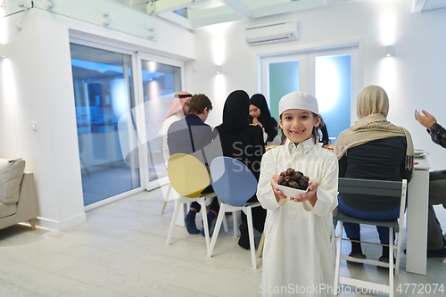 Image of Arabian kid in the traditional clothes during iftar