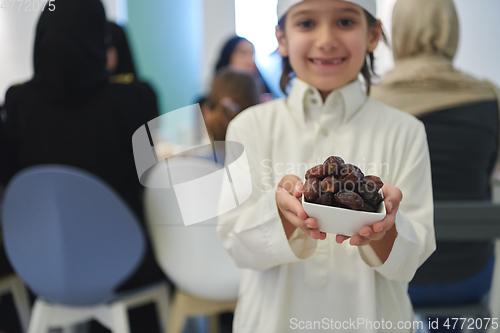 Image of Arabian kid in the traditional clothes during iftar