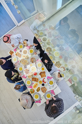 Image of Top view of Muslim family making iftar dua to break fasting during Ramadan.