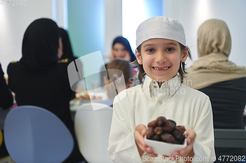 Image of Arabian kid in the traditional clothes during iftar