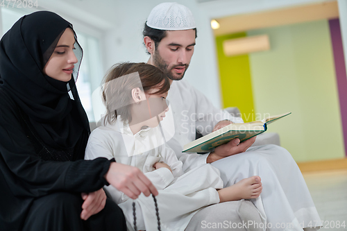 Image of Young muslim family reading Quran during Ramadan