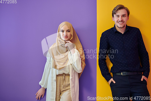 Image of Portrait of happy young muslim couple standing isolated on colorful background