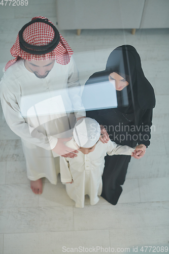 Image of Top view of young arabian muslim family wearing traditional clothes