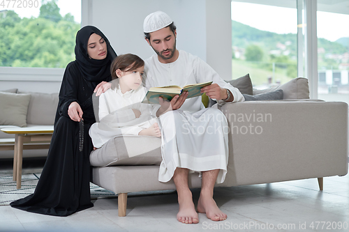 Image of Young muslim family reading Quran during Ramadan