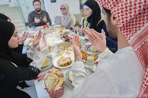 Image of Muslim family making iftar dua to break fasting during Ramadan.