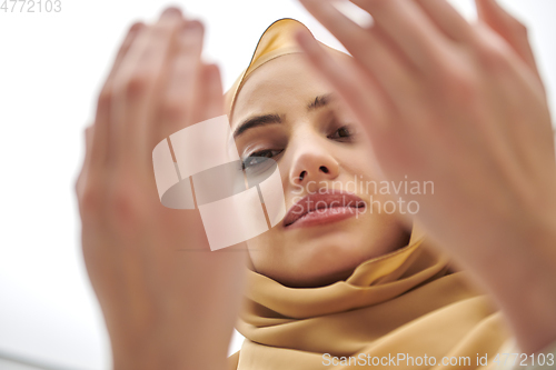 Image of Portrait of young muslim woman making dua, praying to God