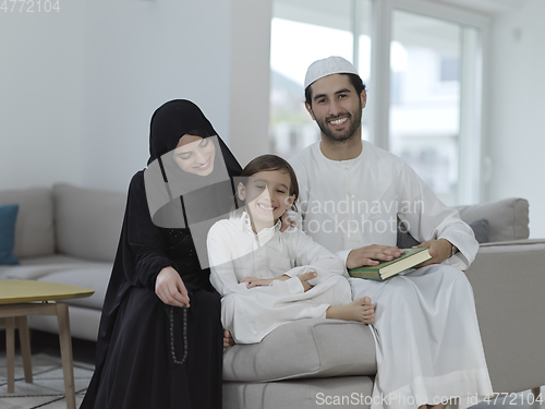 Image of Young muslim family reading Quran during Ramadan