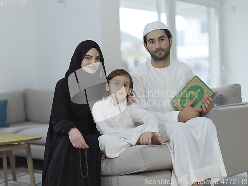 Image of Young muslim family reading Quran during Ramadan