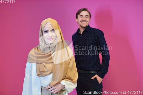 Image of Portrait of happy young muslim couple standing isolated on pink background