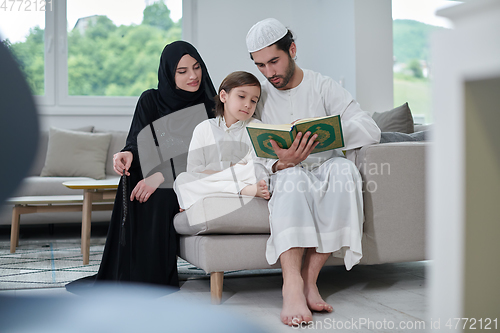 Image of Young muslim family reading Quran during Ramadan