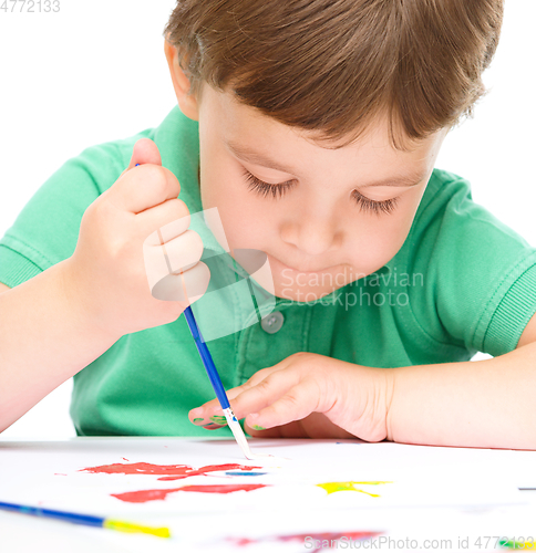 Image of Little boy is playing with paints