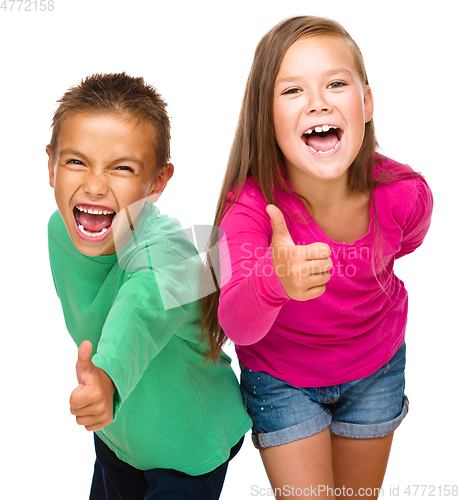 Image of Little boy and girl are showing thumb up sign