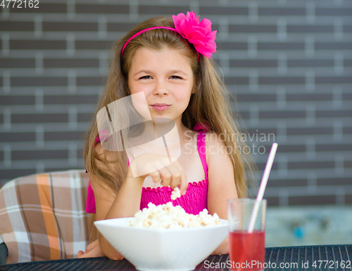 Image of Little girl is drinking cherry juice