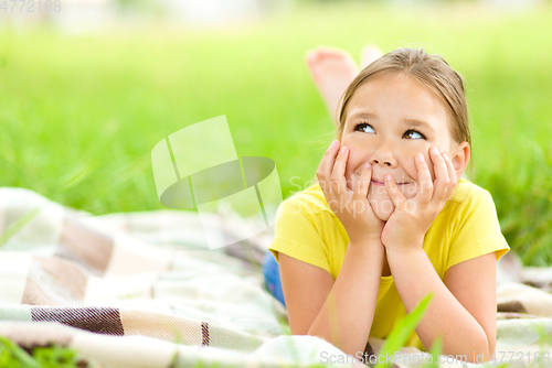 Image of Portrait of a little girl laying on green grass