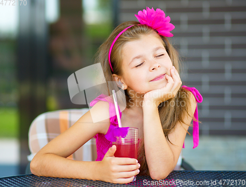Image of Little girl is drinking cherry juice