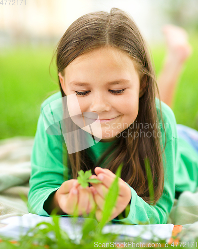 Image of Portrait of a little girl laying on green grass