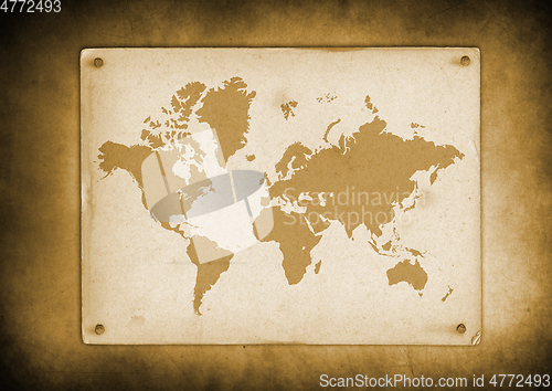 Image of Vintage world map parchment nailed to a wall