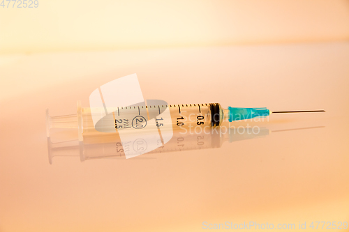 Image of Syringe on orange background