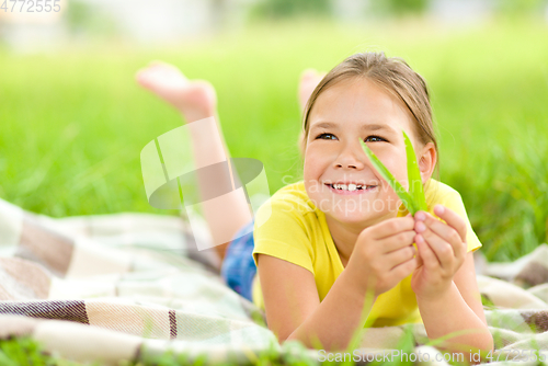 Image of Portrait of a little girl laying on green grass