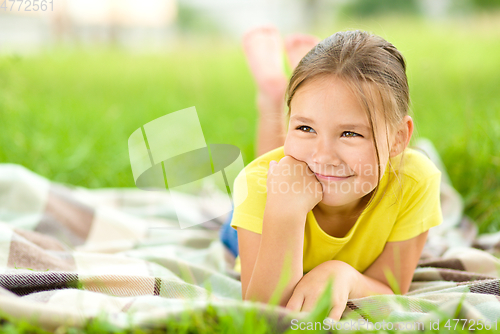 Image of Portrait of a little girl laying on green grass