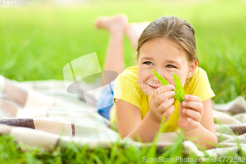 Image of Portrait of a little girl laying on green grass