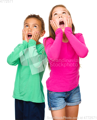 Image of Little girl and boy are holding their faces