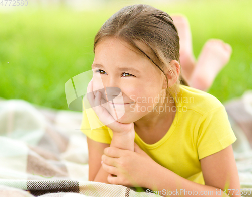 Image of Portrait of a little girl laying on green grass
