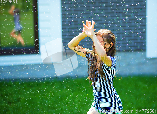 Image of Happy girl is playing under rain