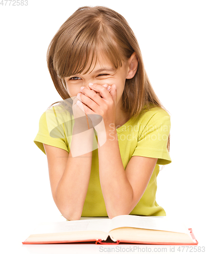 Image of Cheerful young girl is reading book