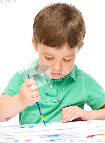 Image of Little boy is playing with paints