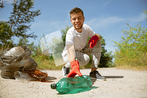 Image of Volunteer tidying up rubbish on beach