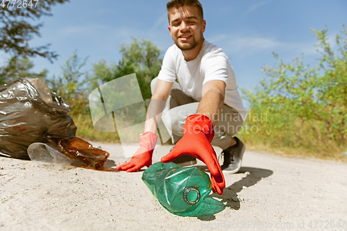 Image of Volunteer tidying up rubbish on beach