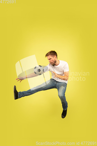 Image of Full length portrait of happy jumping man on yellow background