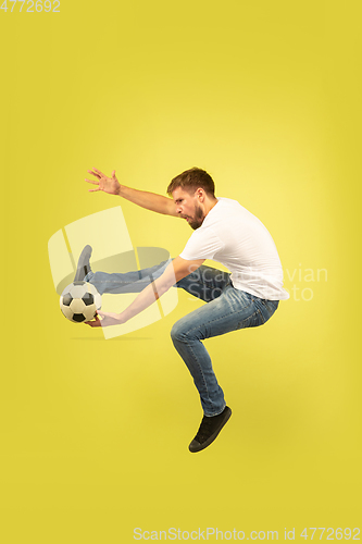 Image of Full length portrait of happy jumping man on yellow background