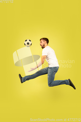 Image of Full length portrait of happy jumping man on yellow background