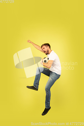 Image of Full length portrait of happy jumping man on yellow background