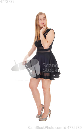 Image of Happy woman standing in a short black dress