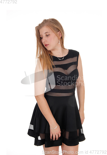 Image of Woman standing in black dress looking down