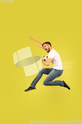 Image of Full length portrait of happy jumping man on yellow background