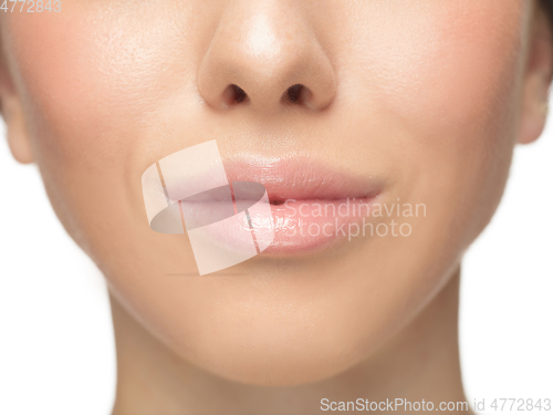 Image of Close up shot of well-kept female big lips and cheeks on white studio background