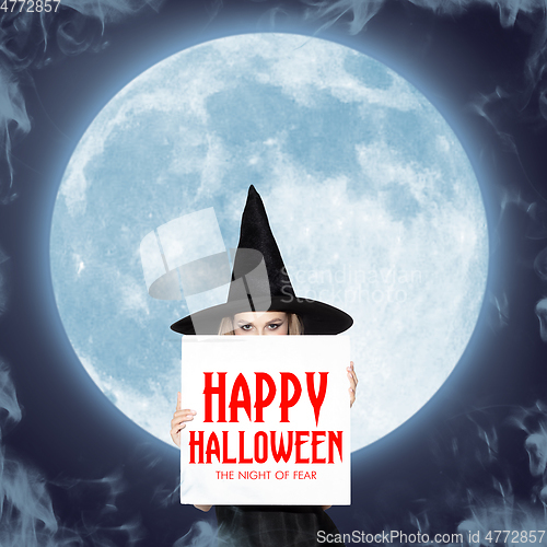 Image of Young woman in hat as a witch on moon background