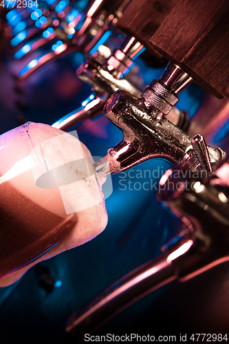 Image of Bartender pouring a large lager beer in tap