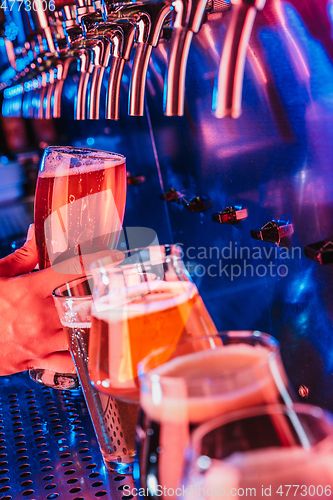 Image of Hand of bartender pouring a large lager beer in tap