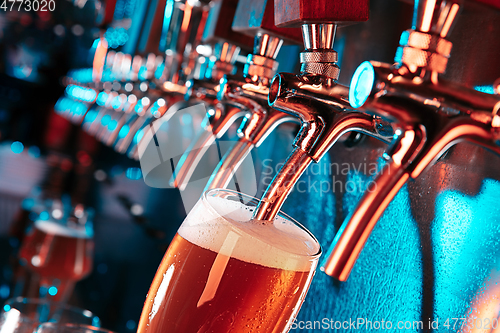 Image of Hand of bartender pouring a large lager beer in tap