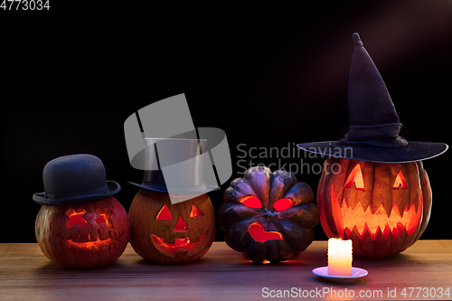 Image of Halloween pumpkin head jack lantern with scary evil faces and candles