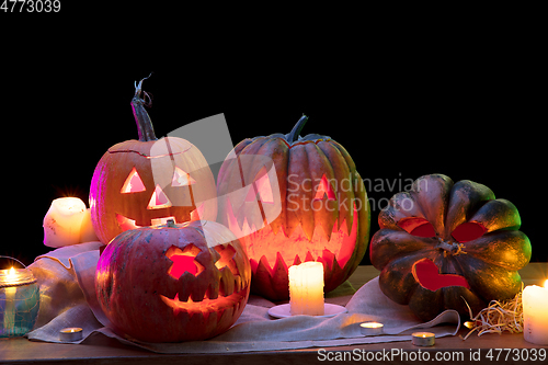 Image of Halloween pumpkin head jack lantern with scary evil faces and candles