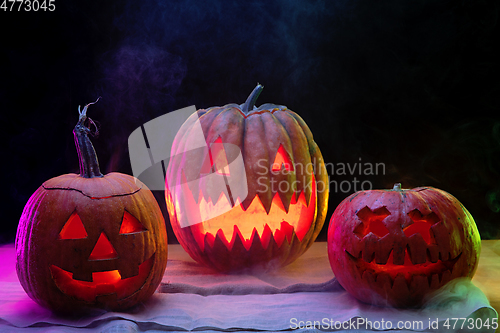 Image of Halloween pumpkin head jack lantern with scary evil faces and candles