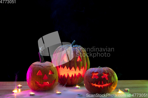 Image of Halloween pumpkin head jack lantern with scary evil faces and candles